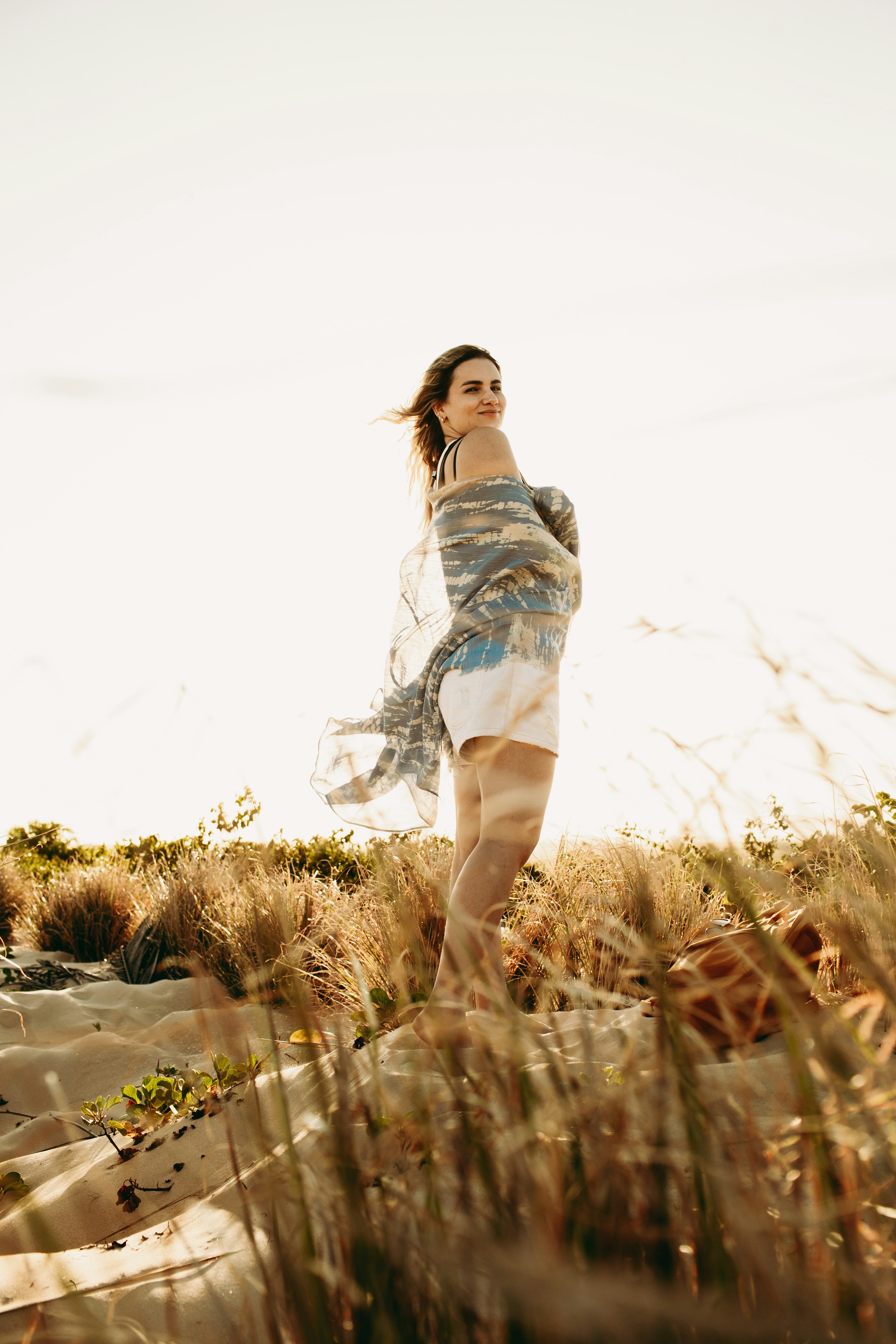 woman in blue and white dress standing on brown grass field during daytime